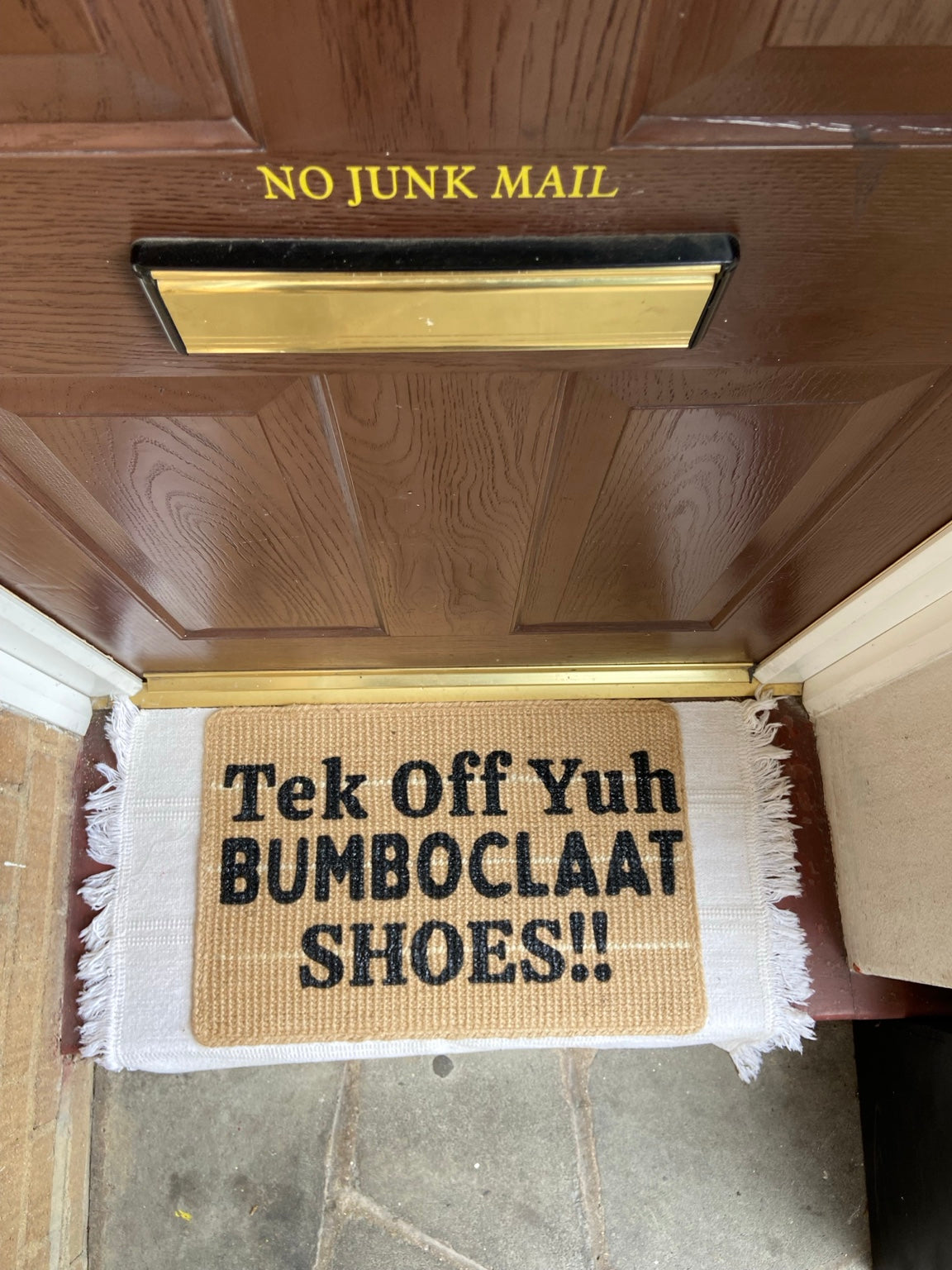 Handmade doormat with the Jamaican saying Tek Off Yuh Bumboclaat Shoes